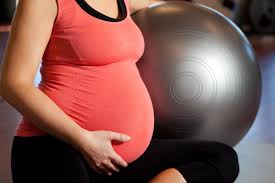 Photo d'une femme enceinte qui fait du Pilates avec un ballon